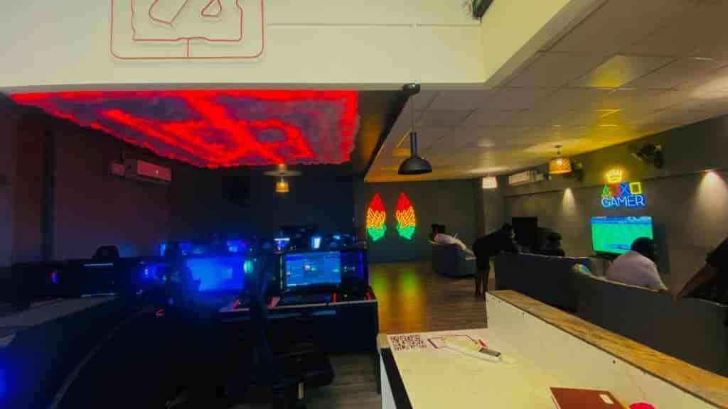 Gaming computers and seating on a neon-lit cafe floor